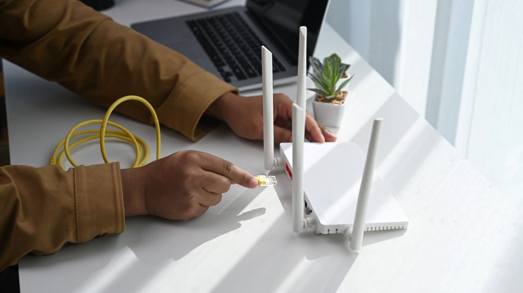 close up view of man-connects the internet cable router