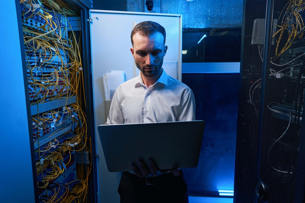 man using laptop near open server cabinet 2021 c3 cayman insert