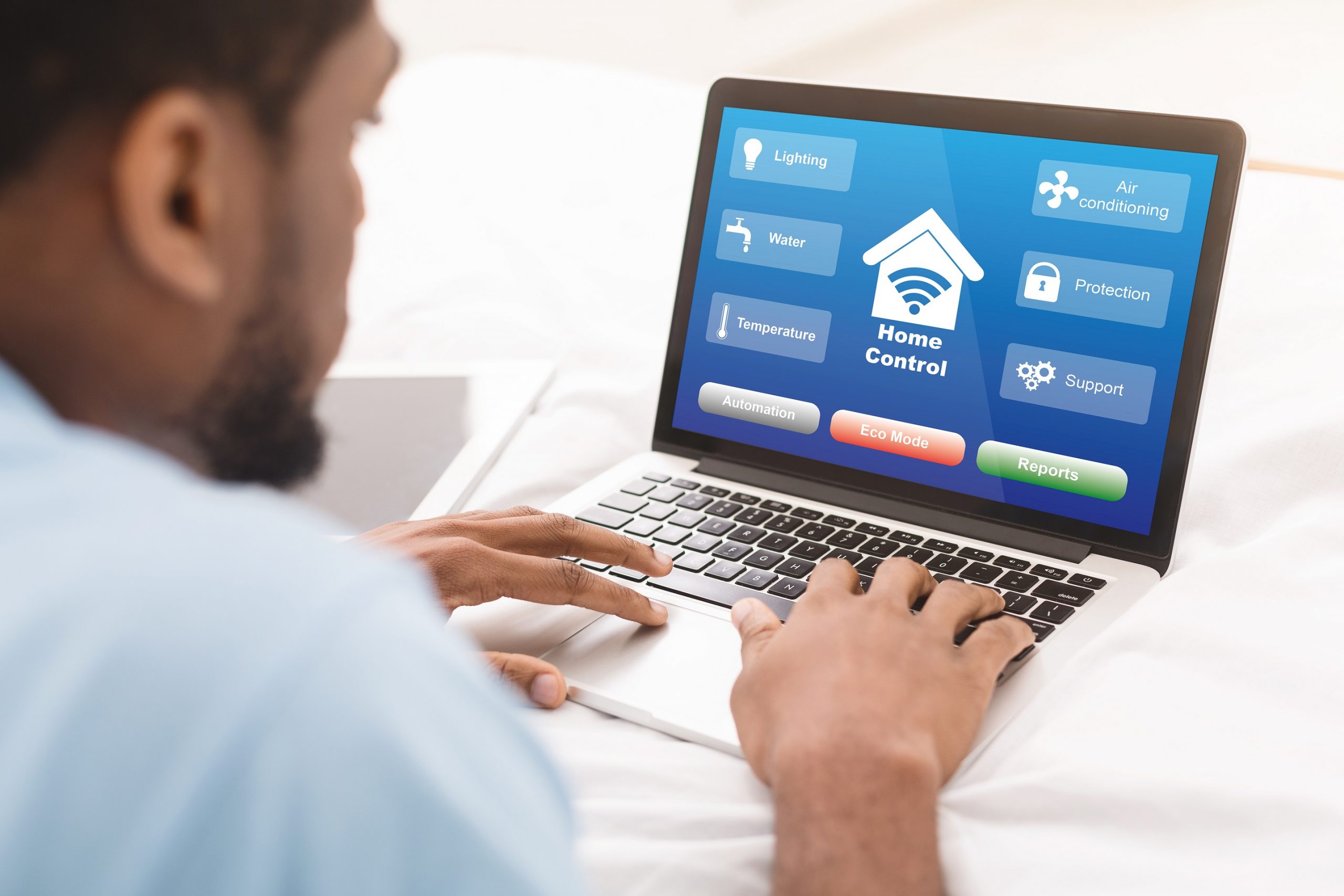 Black Man Using Laptop With Smart Home Control System On Screen