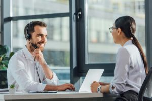 smiling male translator working online with laptop 2022