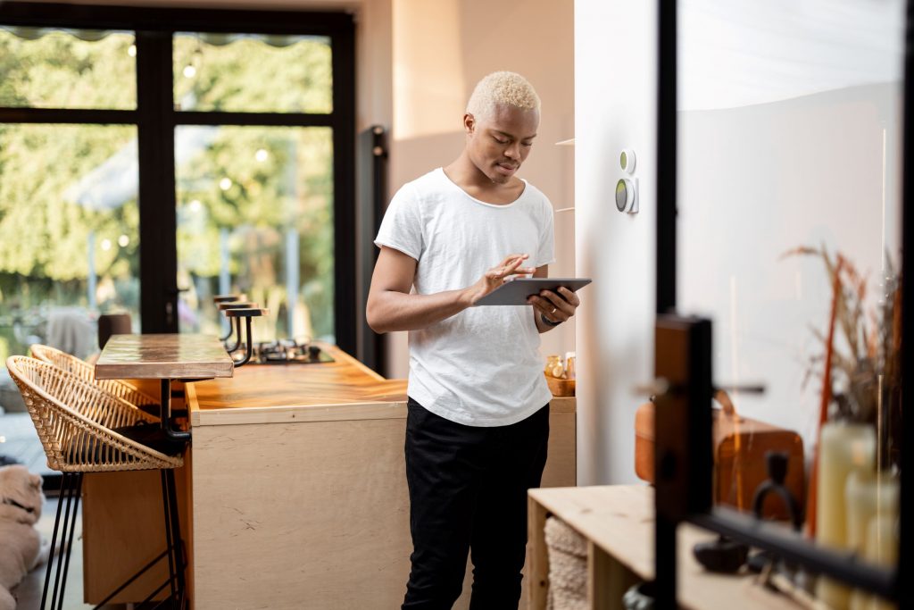 latin man choosing temperature on thermostat