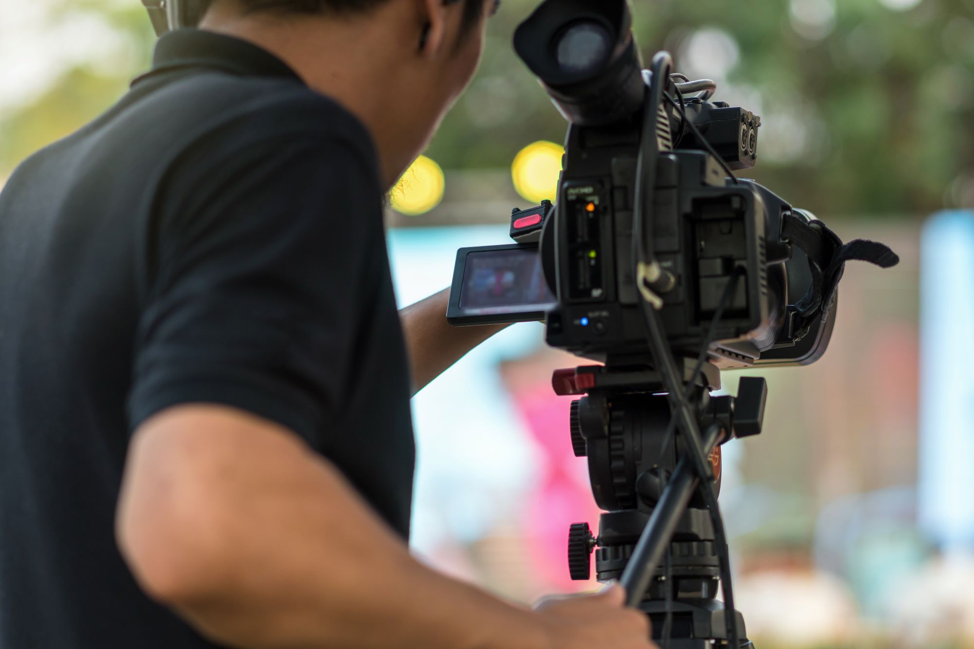 rear side of video cameraman taking photograph