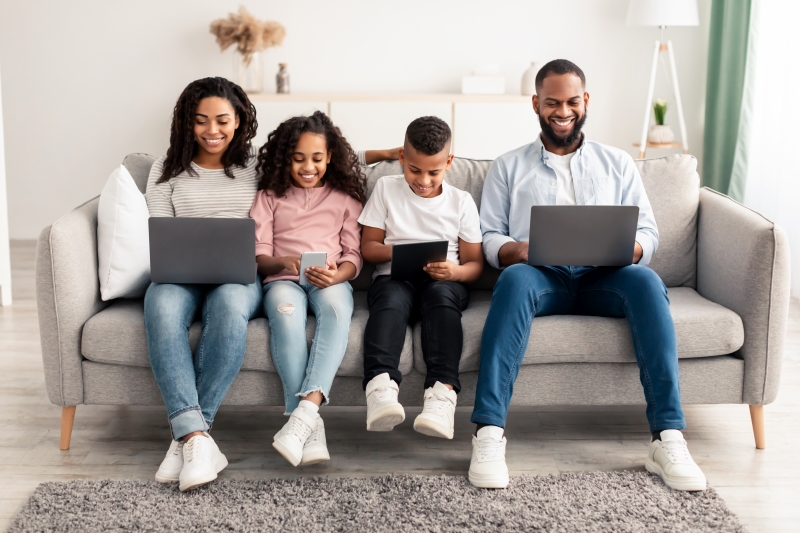 happy-african-american-family-holding-and-using-personal-devices