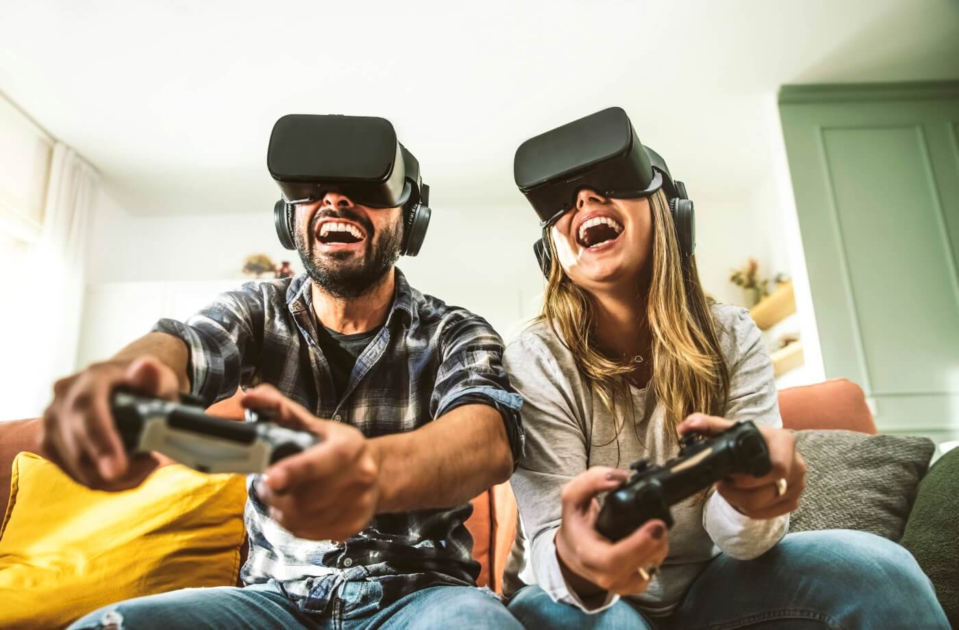 happy-friends-sitting-on-sofa-playing-video-games